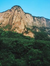 Scenic view of rocky mountains against blue sky