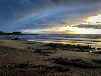 Scenic view of beach against sky during sunset