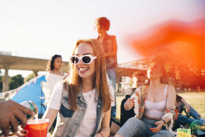 Cropped image of man pouring alcohol to smiling woman at festival