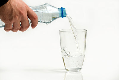 Close-up of hand pouring water from glass