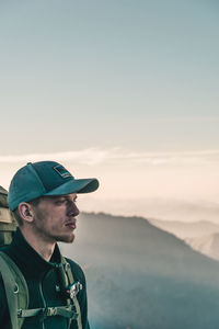 Portrait of man looking away against sky during sunset