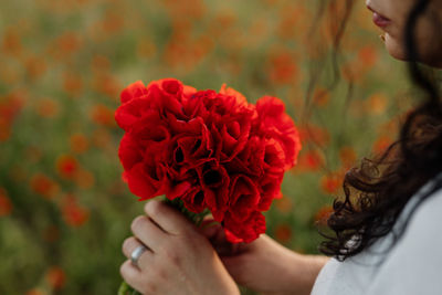 Woman holding bouquet of poppies