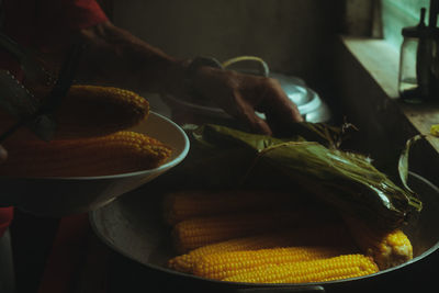Close-up of person preparing food or corn
