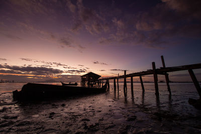 Pier over sea against sky during sunset