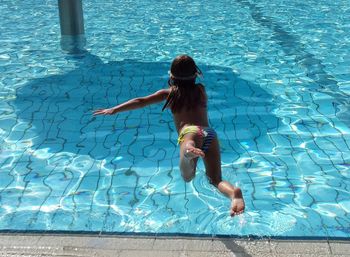 Full length of girl jumping in swimming pool