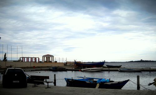 Boats in sea against cloudy sky