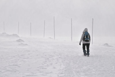 Full length of person walking on snow covered landscape