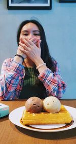 Portrait of young woman sitting on table