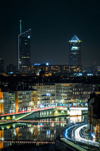 Illuminated buildings in city against sky at night