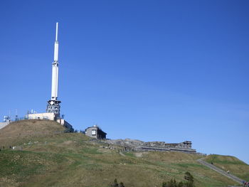 Built structure on landscape against clear blue sky