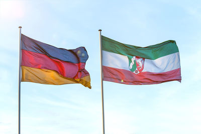 Low angle view of flags against sky