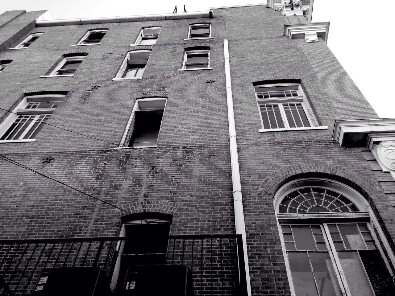 building exterior, architecture, built structure, low angle view, window, building, city, residential building, day, brick wall, outdoors, residential structure, facade, no people, sky, apartment, street light, tower, office building, tall - high