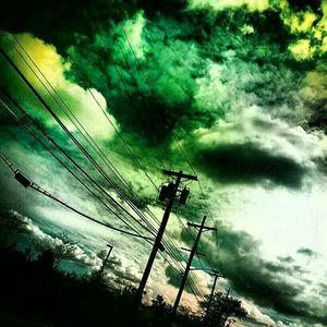 Low angle view of power lines against cloudy sky