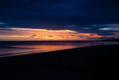 Scenic view of sea against dramatic sky during sunset