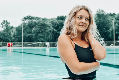 Portrait of young woman standing in swimming pool