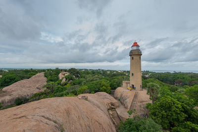 Lighthouse amidst buildings against sky