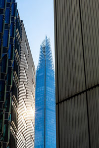 Low angle view of modern buildings against clear blue sky