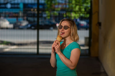 Young woman wearing sunglasses standing outdoors