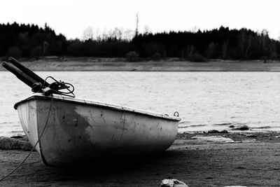 Boat moored on beach against sky