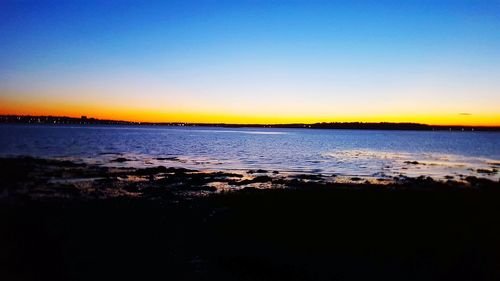 Scenic view of sea against clear sky at sunset