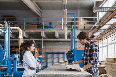 Business people having discussion over document while working at industry