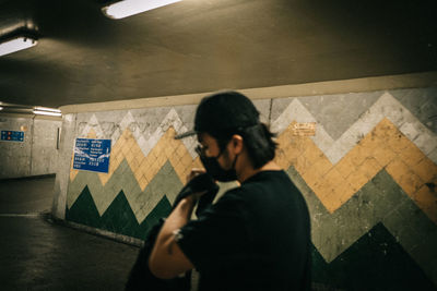 Man and woman standing against wall at subway