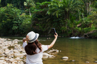 Rear view of woman photographing with mobile phone