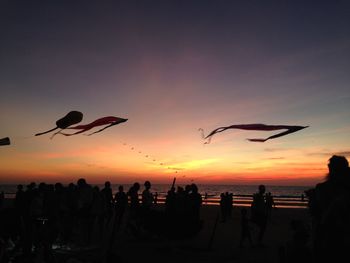 Silhouette people at beach during sunset