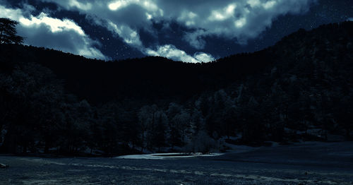 Scenic view of mountains against sky at night