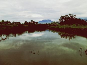 Scenic view of lake against cloudy sky