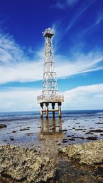 Lifeguard tower by sea against sky