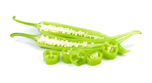 Close-up of green chili pepper against white background