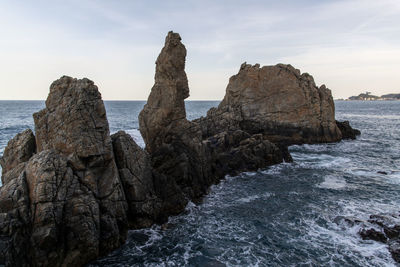 Rocks on beach against sky