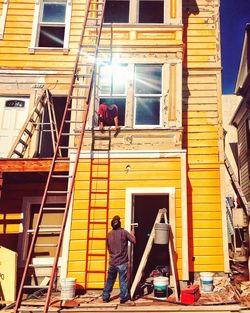 People in front of yellow building