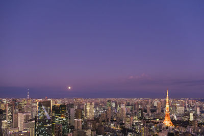 Illuminated buildings in city against sky at night