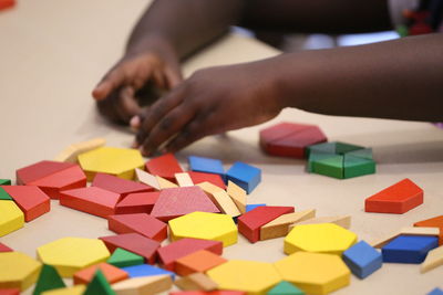 Close-up cropped girl playing with toy blocks on table