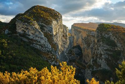View of rock formation against cloudy sky