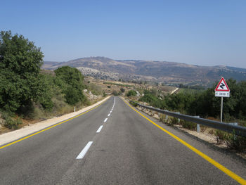 Road by mountains against clear sky