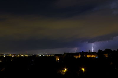 Lightning over illuminated city at night