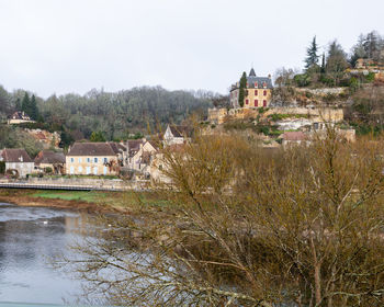 River and houses against sky in town