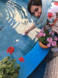 High angle view of woman standing by swimming pool