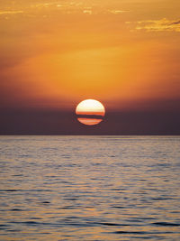 Scenic view of sea against orange sky