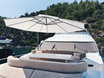 Boat moored by lake against sky