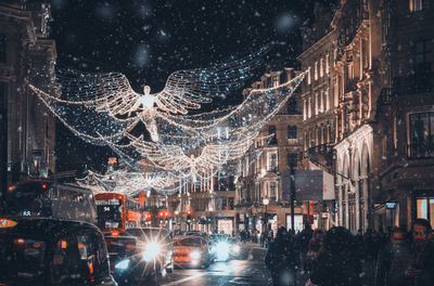 Illuminated buildings in city at night during winter