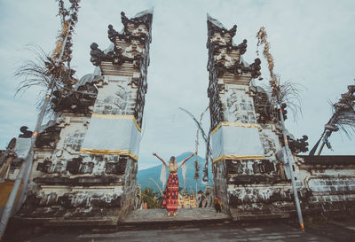 Young woman standing at temple gate