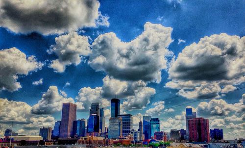 Modern cityscape against cloudy sky