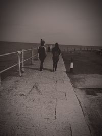 Rear view of people walking on beach