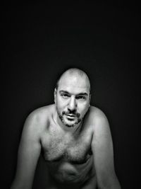 Portrait of young man against black background