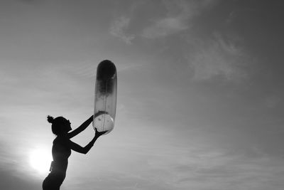 Low angle view of woman with inflatable ring against sky