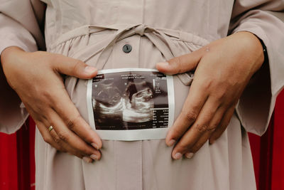 Midsection of man holding camera